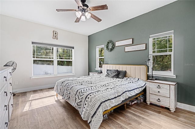 bedroom featuring multiple windows, ceiling fan, and light hardwood / wood-style flooring