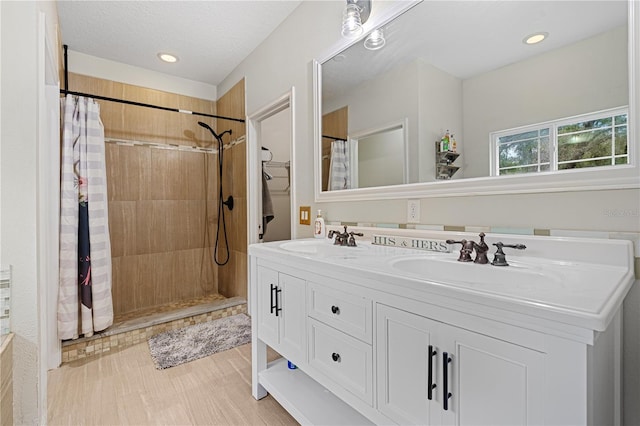 bathroom featuring vanity, curtained shower, and a textured ceiling