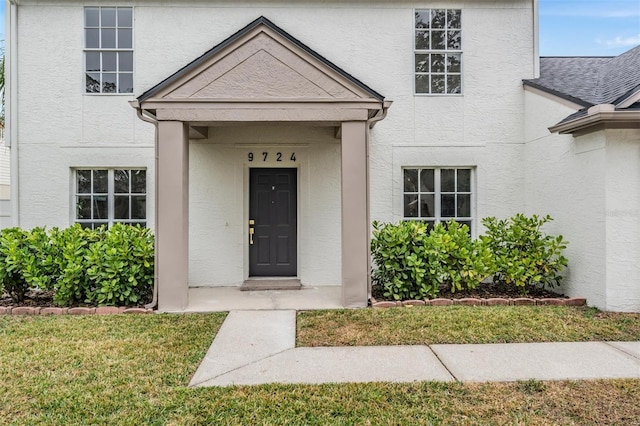 property entrance featuring a lawn