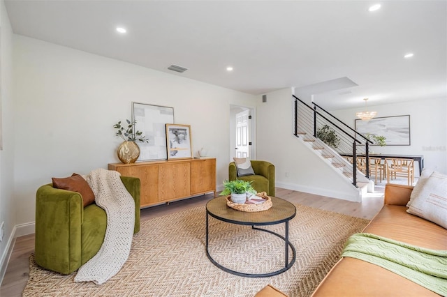 living room featuring light hardwood / wood-style floors and a chandelier