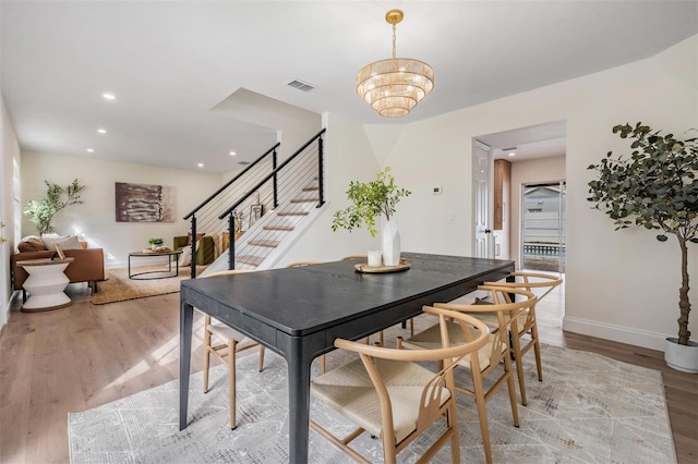 dining area featuring hardwood / wood-style floors and a notable chandelier