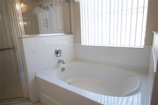 bathroom featuring a healthy amount of sunlight and shower with separate bathtub