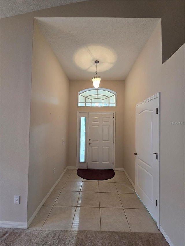 tiled entrance foyer featuring a textured ceiling