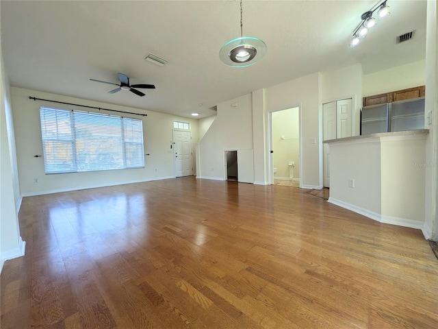 unfurnished living room with light wood finished floors, ceiling fan, and visible vents