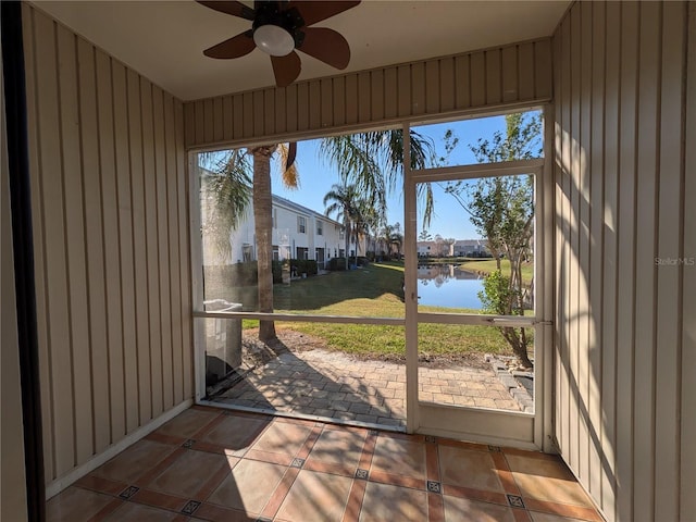 sunroom with a water view, a residential view, and a ceiling fan