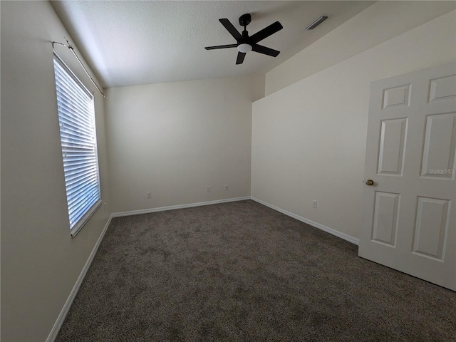 carpeted spare room featuring a textured ceiling, a ceiling fan, visible vents, vaulted ceiling, and baseboards