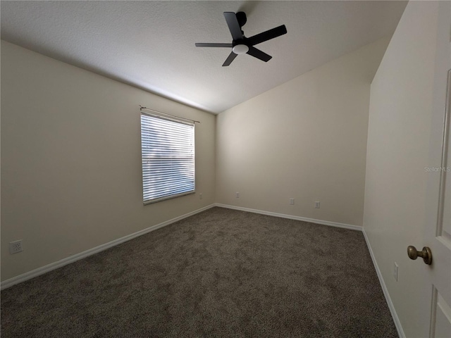 unfurnished room featuring a ceiling fan, vaulted ceiling, dark carpet, and baseboards