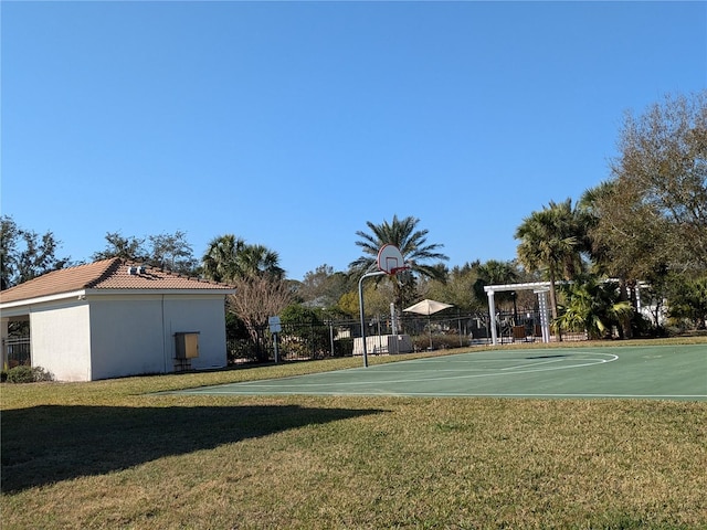 view of basketball court with community basketball court, a yard, and fence