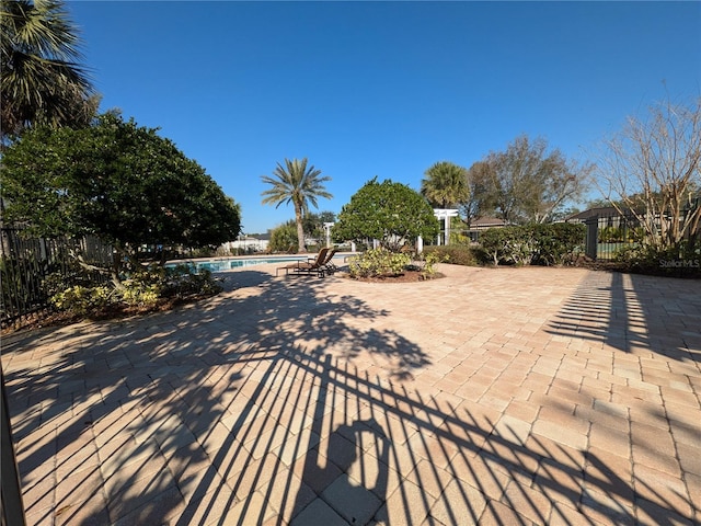 view of patio with fence and a community pool