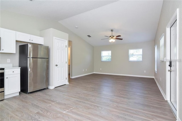 kitchen with white cabinetry, vaulted ceiling, light hardwood / wood-style flooring, and appliances with stainless steel finishes