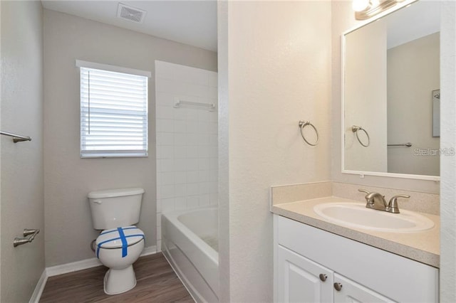 full bathroom featuring tiled shower / bath, vanity, toilet, and hardwood / wood-style floors