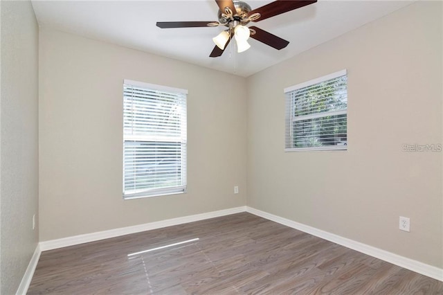 spare room featuring hardwood / wood-style flooring, ceiling fan, and a healthy amount of sunlight