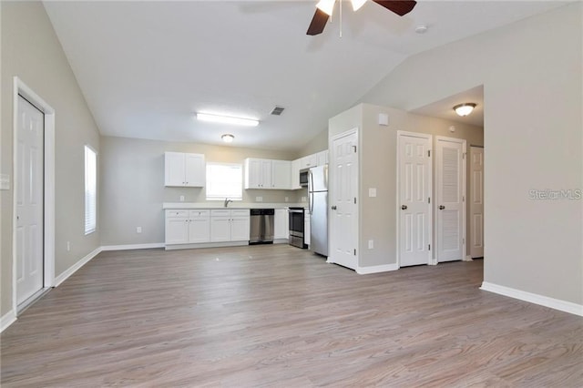 unfurnished living room featuring vaulted ceiling, sink, ceiling fan, and light hardwood / wood-style floors