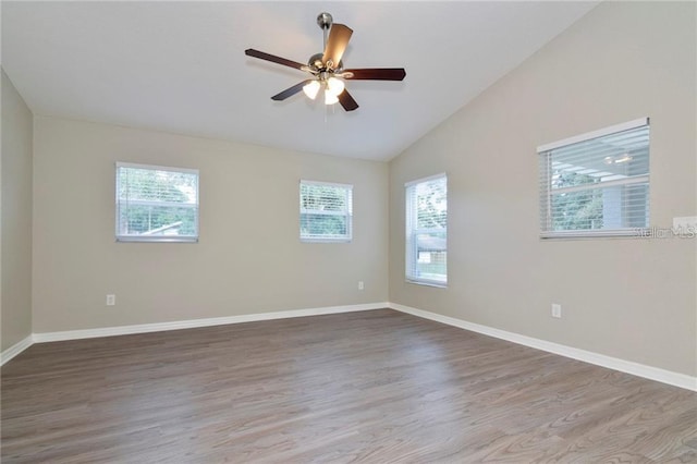 unfurnished room with hardwood / wood-style floors, lofted ceiling, a wealth of natural light, and ceiling fan