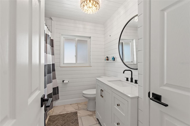 bathroom with vanity, toilet, a notable chandelier, and wood walls