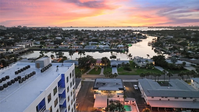 aerial view at dusk featuring a water view