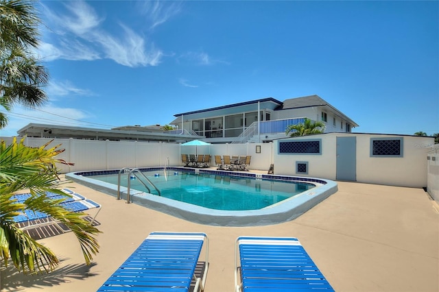 view of pool featuring a sunroom and a patio area