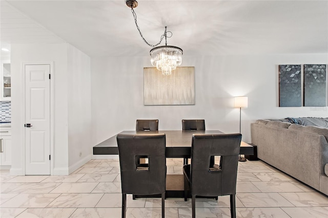 dining area featuring an inviting chandelier, baseboards, and marble finish floor