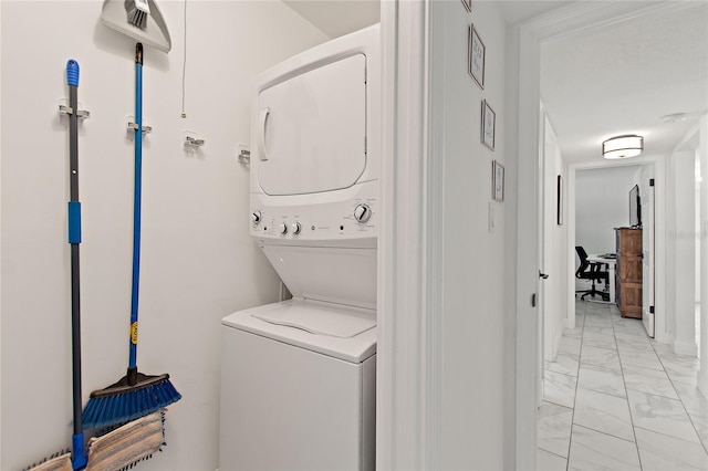 laundry area featuring laundry area, marble finish floor, and stacked washer and dryer