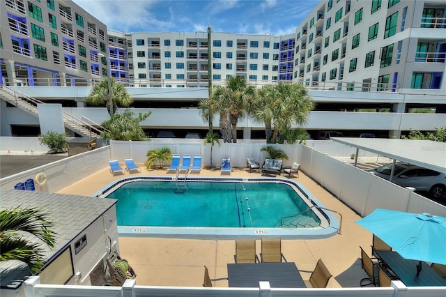 community pool with a patio and fence