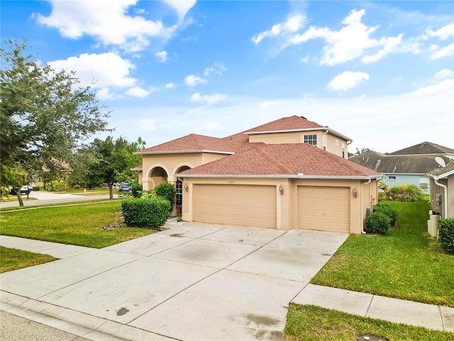 mediterranean / spanish home with a garage and a front lawn