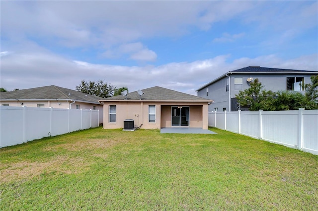 back of property with a patio, a yard, and central air condition unit