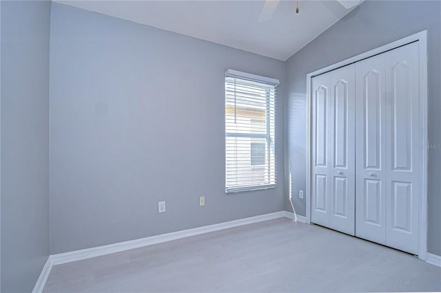 unfurnished bedroom with light wood-type flooring, ceiling fan, and a closet