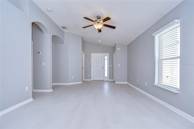 spare room with ceiling fan, lofted ceiling, and light wood-type flooring