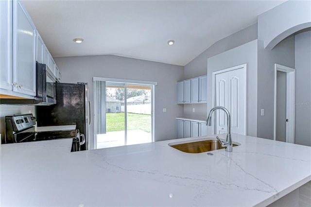 kitchen with stainless steel appliances, kitchen peninsula, sink, and white cabinets