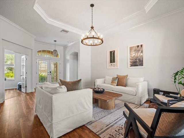 living room featuring a raised ceiling, crown molding, hardwood / wood-style floors, and french doors