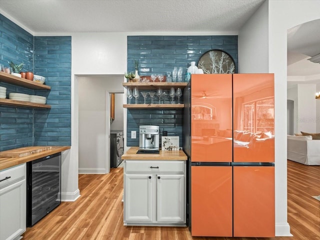 bar with beverage cooler, refrigerator, butcher block counters, and white cabinets