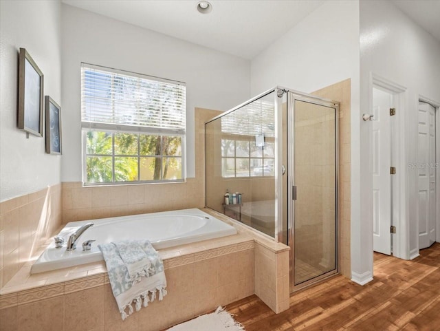 bathroom with hardwood / wood-style floors and independent shower and bath