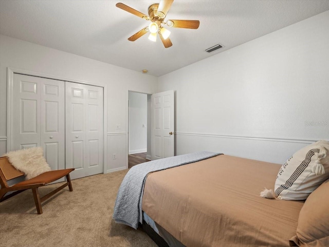 carpeted bedroom with ceiling fan and a closet