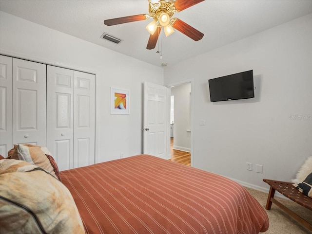 bedroom featuring light carpet, ceiling fan, and a closet