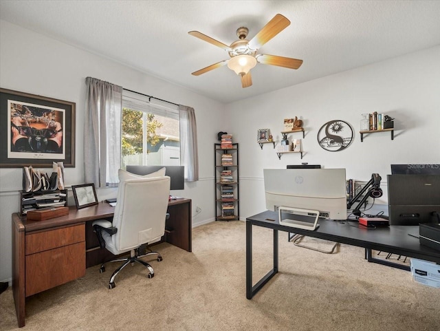 carpeted office space featuring a textured ceiling and ceiling fan