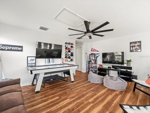 living room with ceiling fan, wood-type flooring, and a textured ceiling