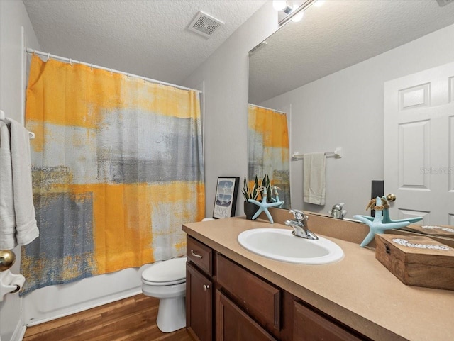 full bathroom featuring toilet, a textured ceiling, vanity, shower / bath combo, and hardwood / wood-style flooring