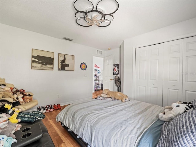 bedroom featuring hardwood / wood-style floors, a textured ceiling, and a closet