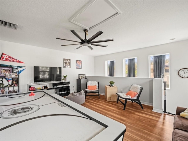 recreation room with hardwood / wood-style floors and a textured ceiling