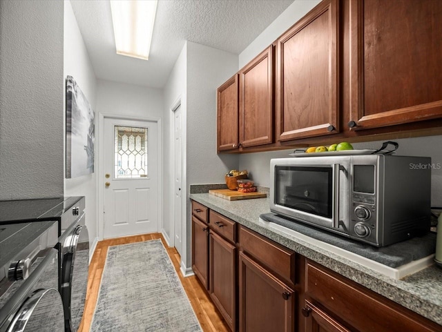 kitchen with a textured ceiling and light wood-type flooring