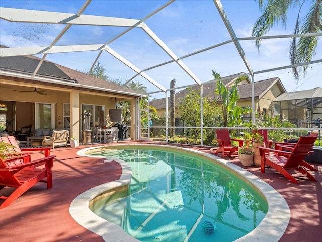 view of pool with glass enclosure and a patio area