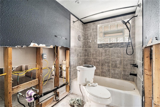 bathroom with tiled shower / bath, a textured ceiling, and toilet