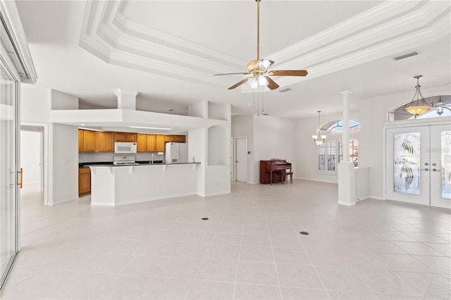 unfurnished living room with french doors, light tile patterned floors, ornamental molding, a raised ceiling, and ceiling fan with notable chandelier