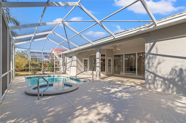 view of pool featuring an in ground hot tub, ceiling fan, a patio area, and glass enclosure