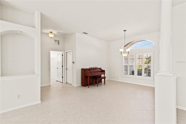 unfurnished room featuring decorative columns, light tile patterned flooring, and a notable chandelier