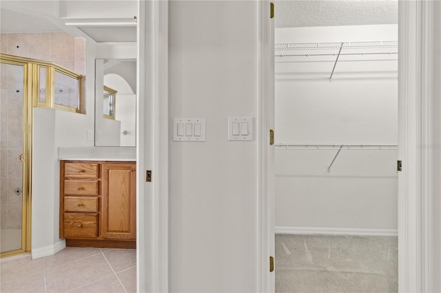 bathroom with tile patterned floors, an enclosed shower, and vanity