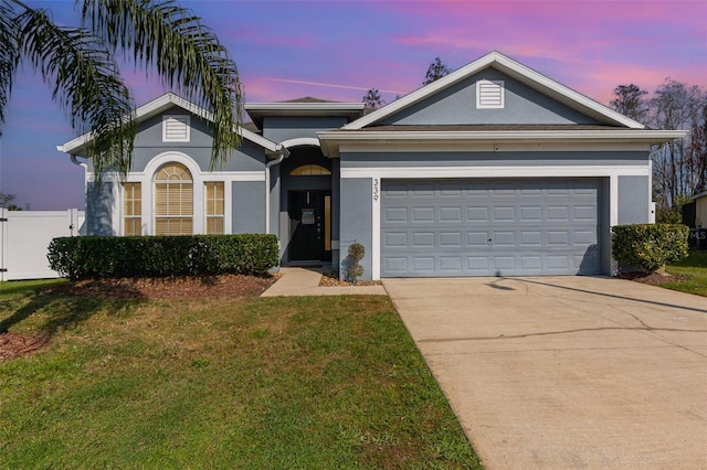 view of front of house with a garage and a yard