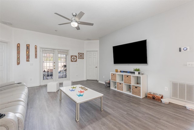 living room with french doors, ceiling fan, and dark wood-type flooring