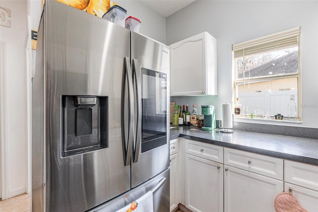 kitchen with stainless steel refrigerator with ice dispenser and white cabinets