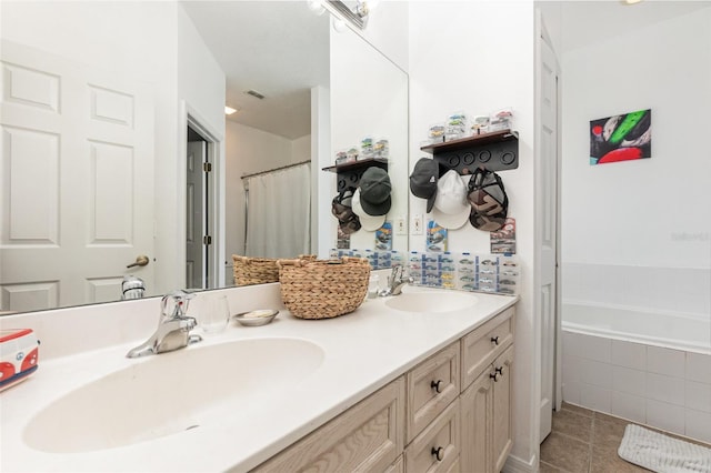 bathroom with vanity, a relaxing tiled tub, and tile patterned floors